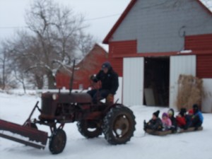 A more modern version of winter fun on the Rocke farm--dad on the tractor pulling some of my nieces and nephews on a hom-made sled.